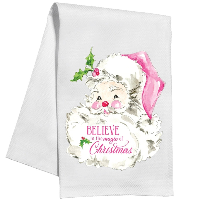 White towel with a Christmas-themed design featuring a large santa face with pink hat and 'Believe in the magic of Christmas' text.
