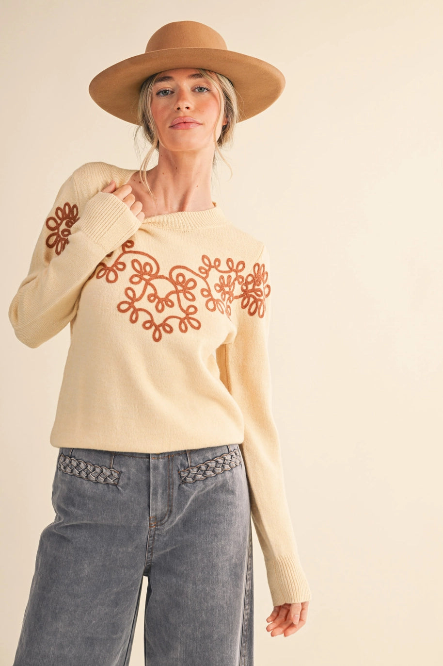 cream long sleeve sweater with camel colored swirly embroidered detail 