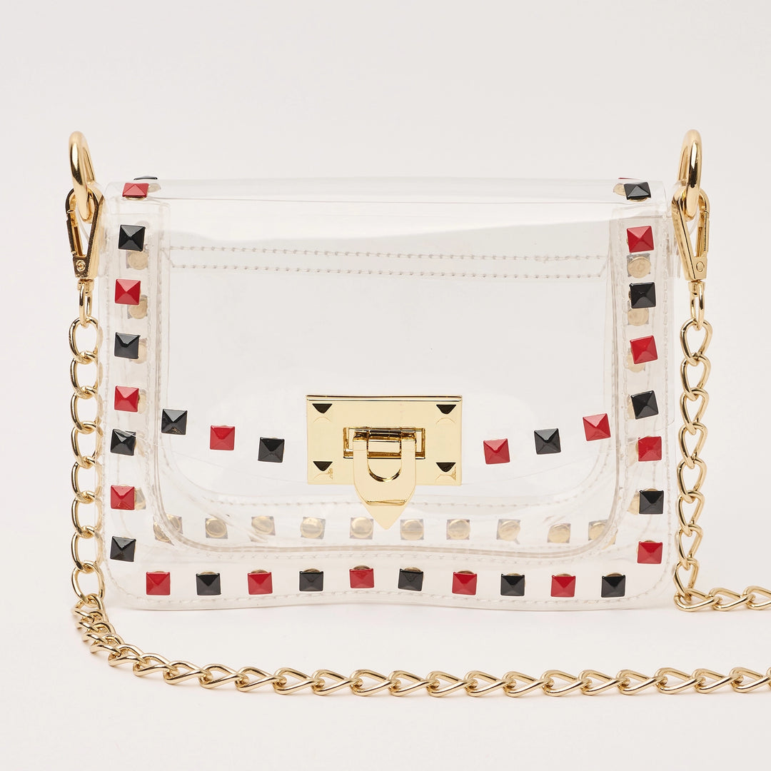 transparent handbag with red and black studded details and a gold chain strap 