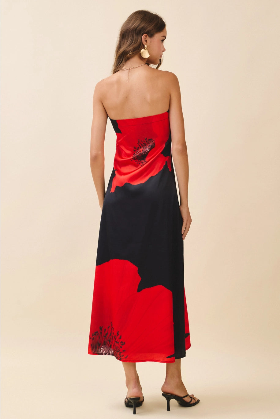 Woman wearing a red and black strapless dress on a beige background