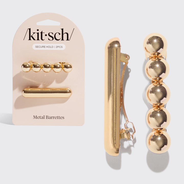2 Gold metal barrettes with packaging labeled 'kitsch' one plain and on bubble circles throughout